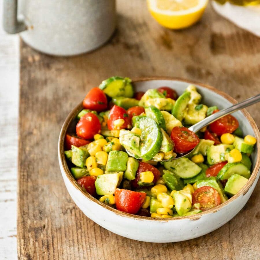 Avocado Tomato Corn Salad in serving bowl on butcher block