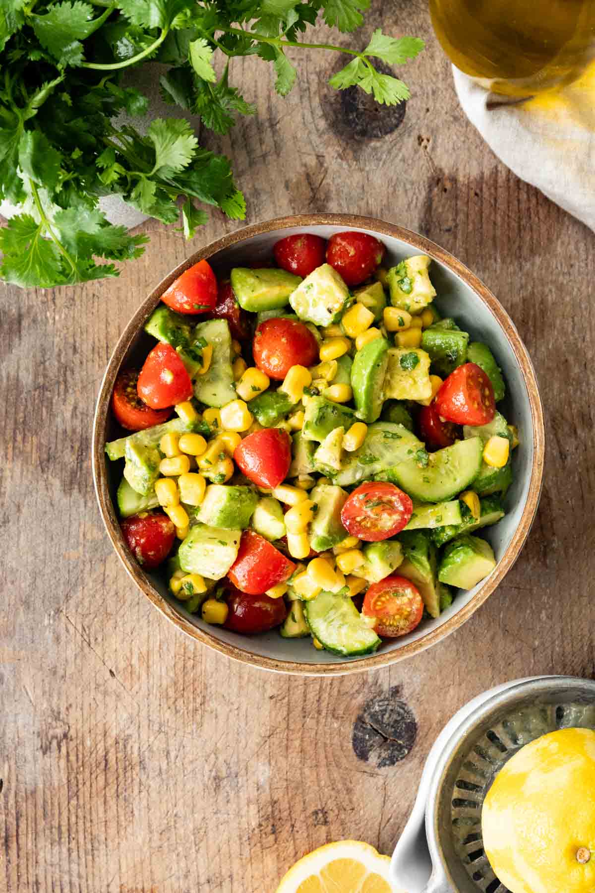 Avocado Tomato Corn Salad in serving bowl on butcher block