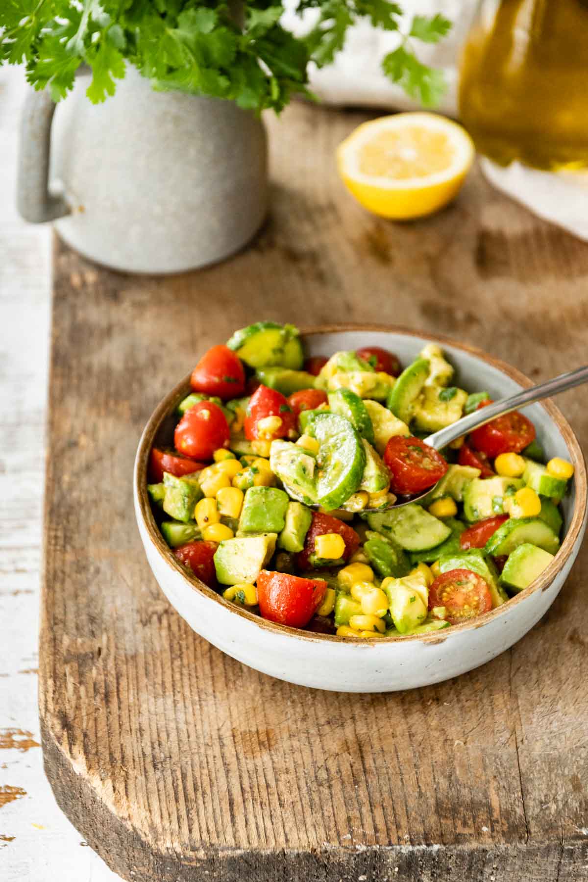 Avocado Tomato Corn Salad in serving bowl on butcher block