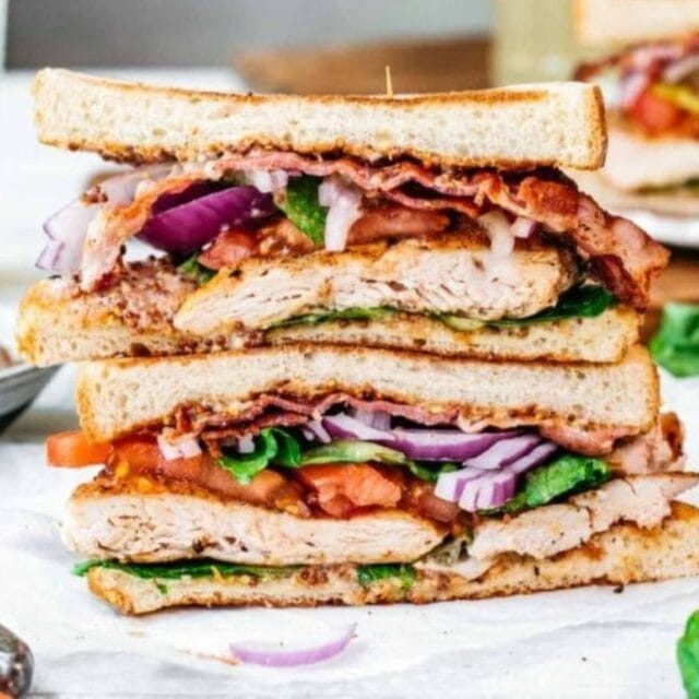 Two halves of the sandwich stacked on a plate.