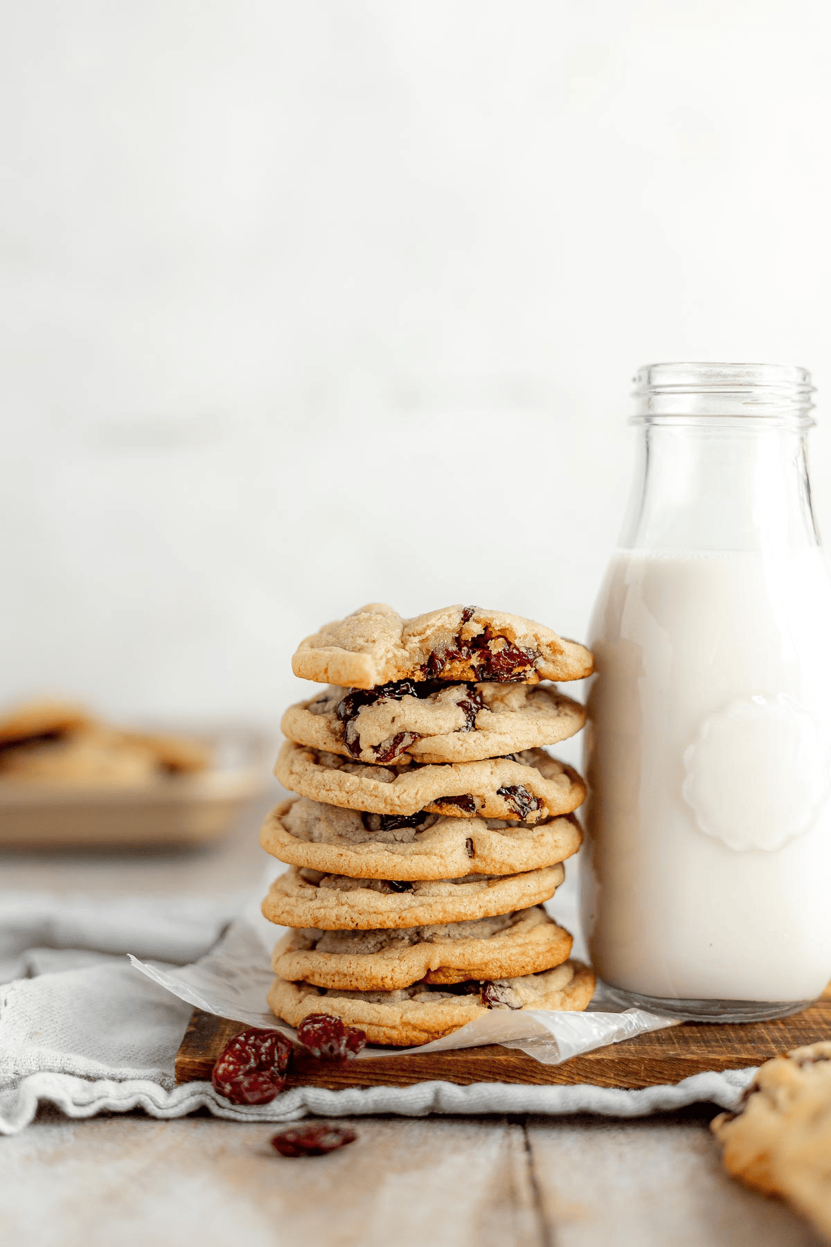 Stack of cookies next to glass milk bottle