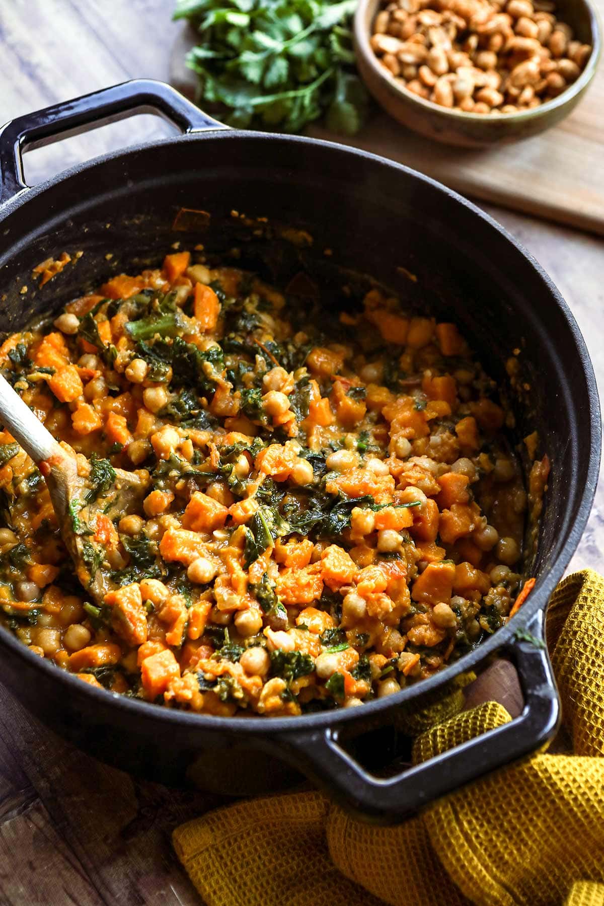 African Peanut Sweet Potato Stew in dutch oven with wooden spoon