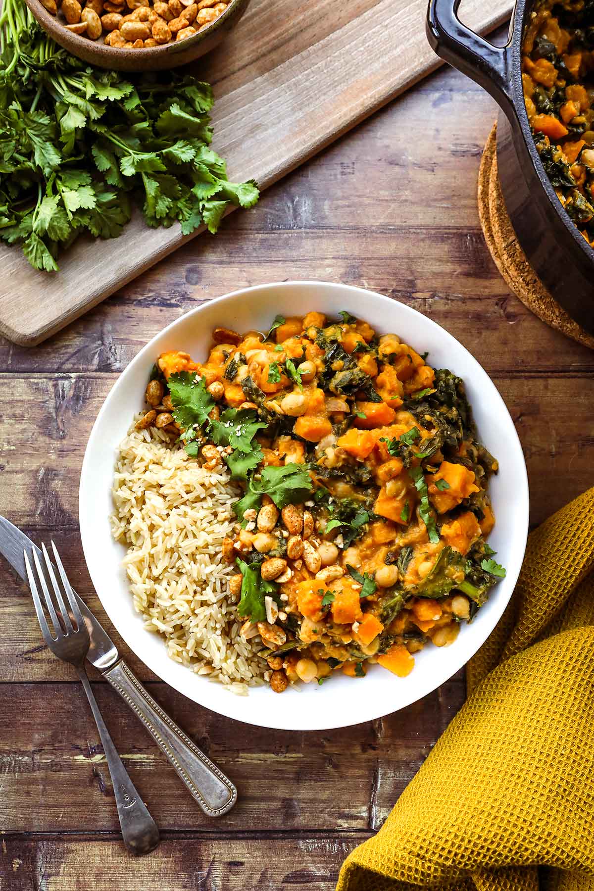 African Peanut Sweet Potato Stew in bowl over rice with cilantro & peanut garnish