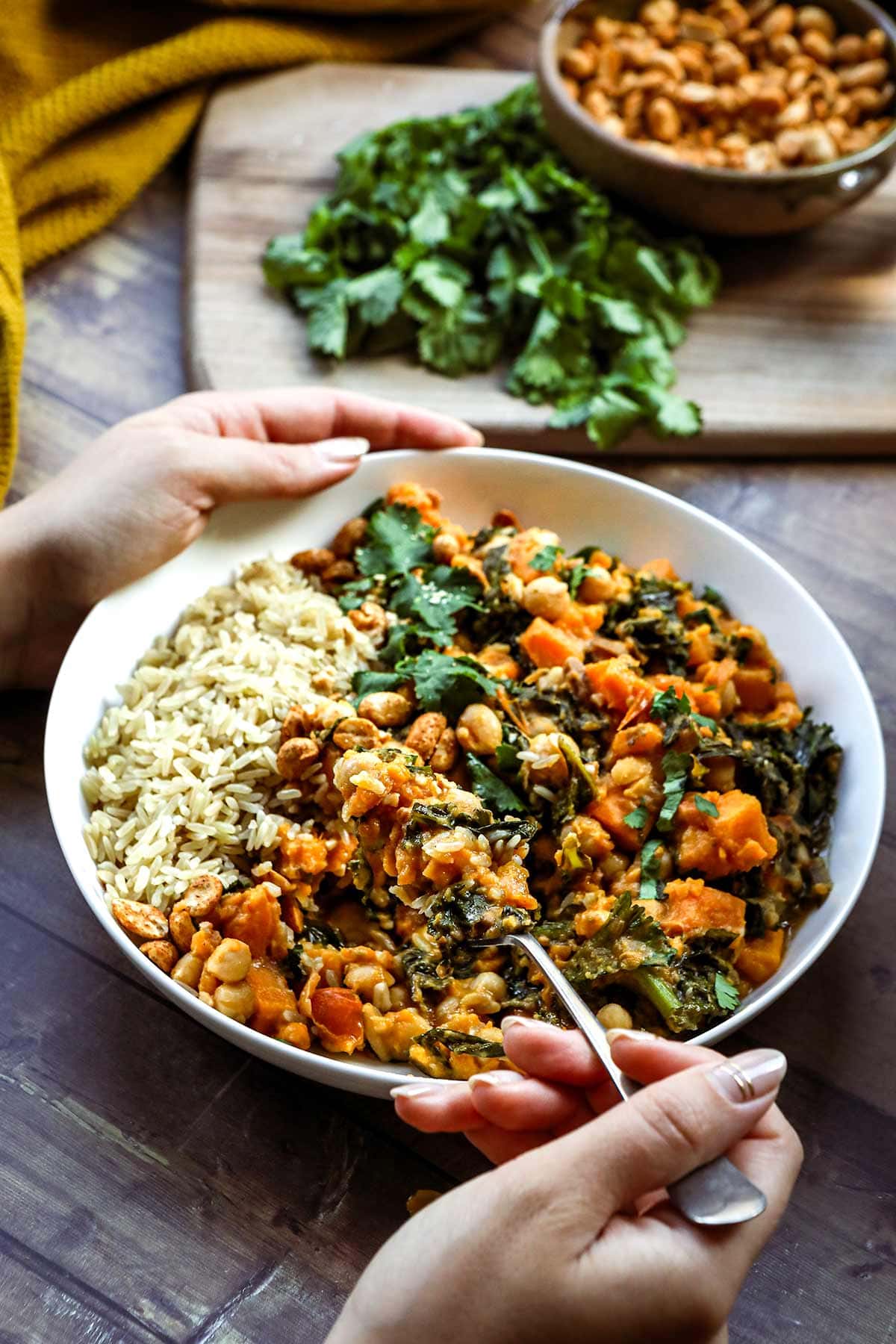 African Peanut Sweet Potato Stew in bowl over rice with cilantro & peanut garnish