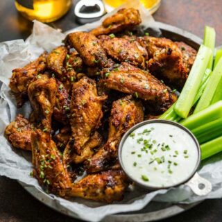 Baked Chicken Wings on serving plate with celery and creamy dip