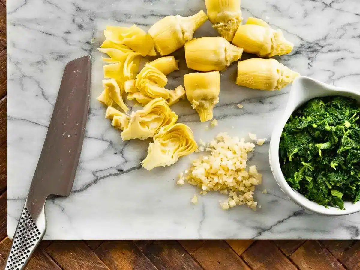 Artichokes and spinach on cutting board