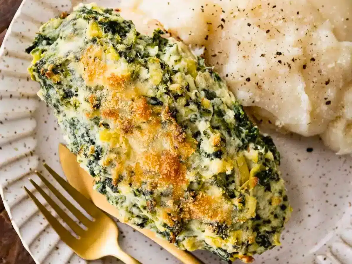 Baked chicken with topping next to mashed potatoes