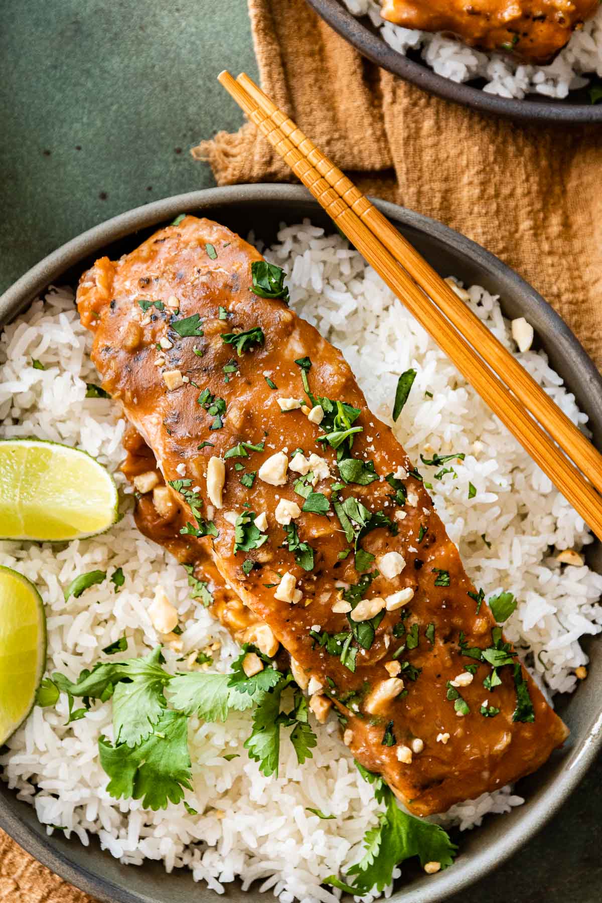 Baked Thai Peanut Salmon in serving bowl with rice and lime wedges