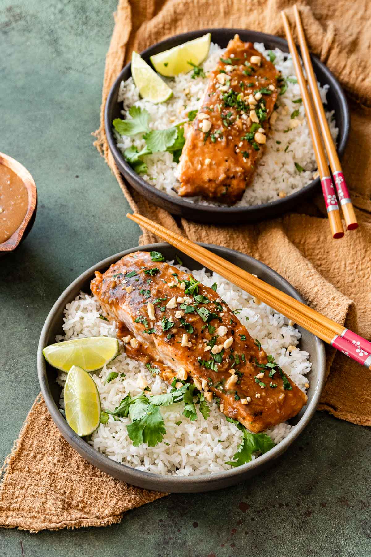 Baked Thai Peanut Salmon in serving bowl with rice and lime wedges