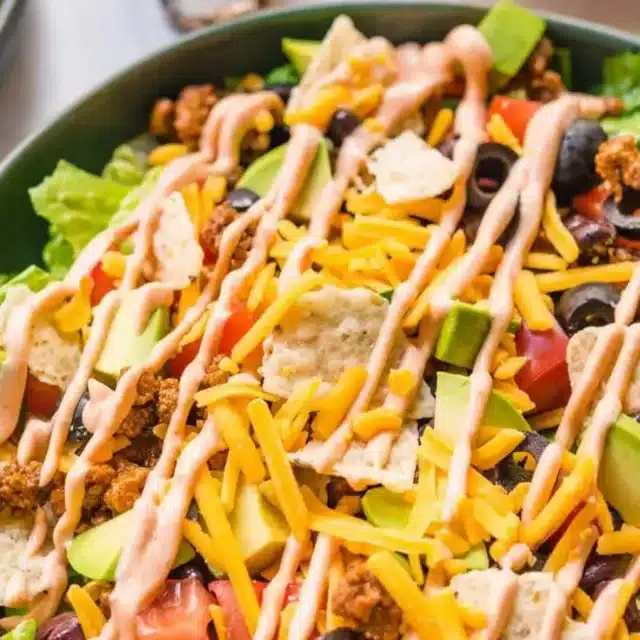 salad with chips and beef topped with dressing