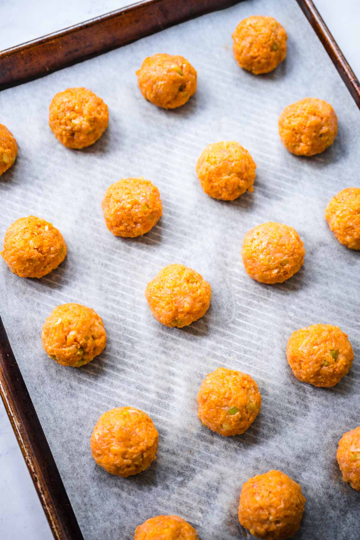 Buffalo Chicken Meatballs formed meatballs on baking pan before cooking