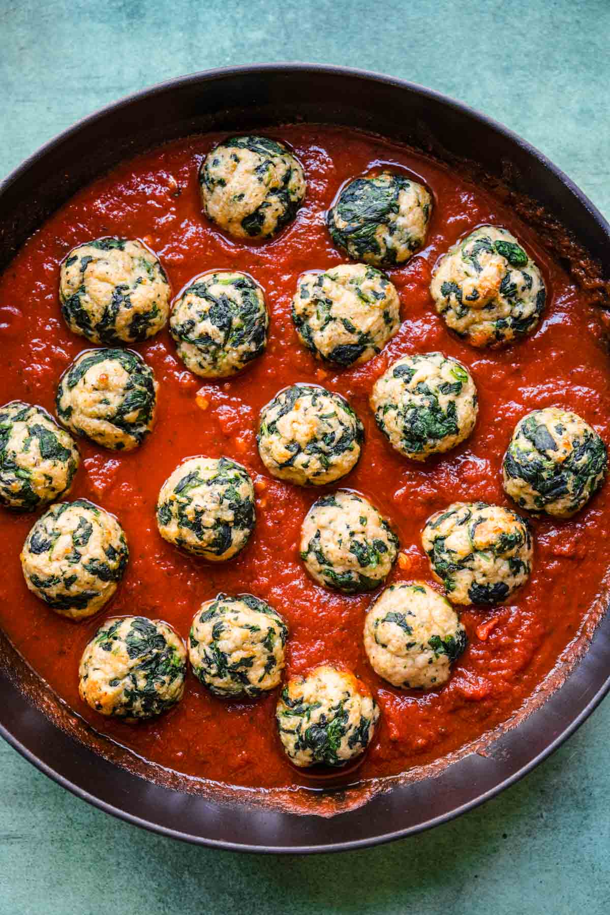 Chicken Florentine Meatballs simmering in marinara sauce