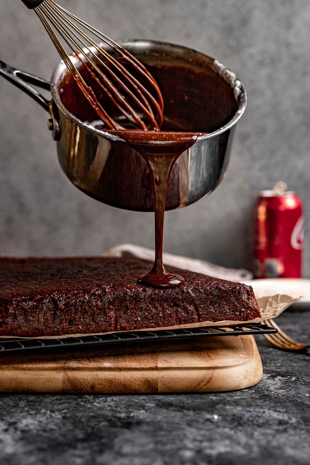 Coca Cola Sheet Cake frosting poured over cake