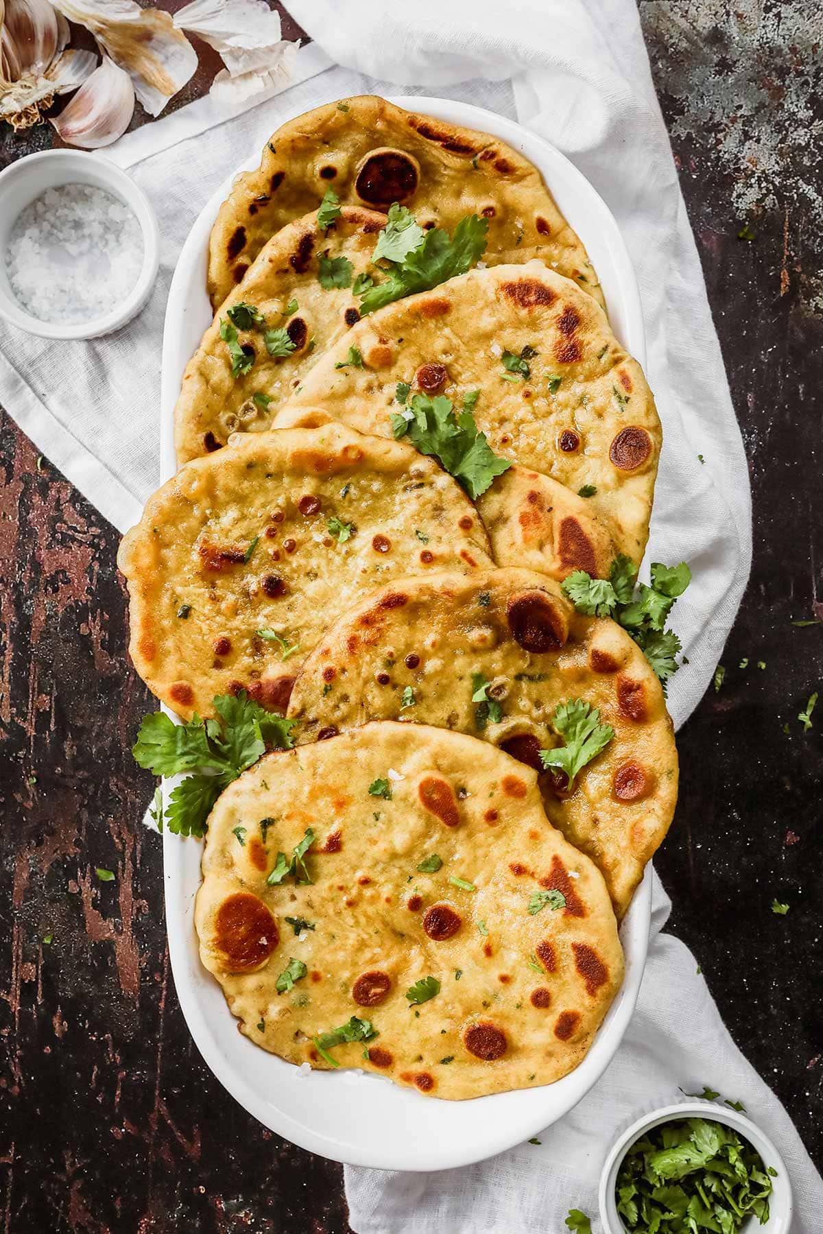 Garlic Naan in serving dish with cilantro garnish