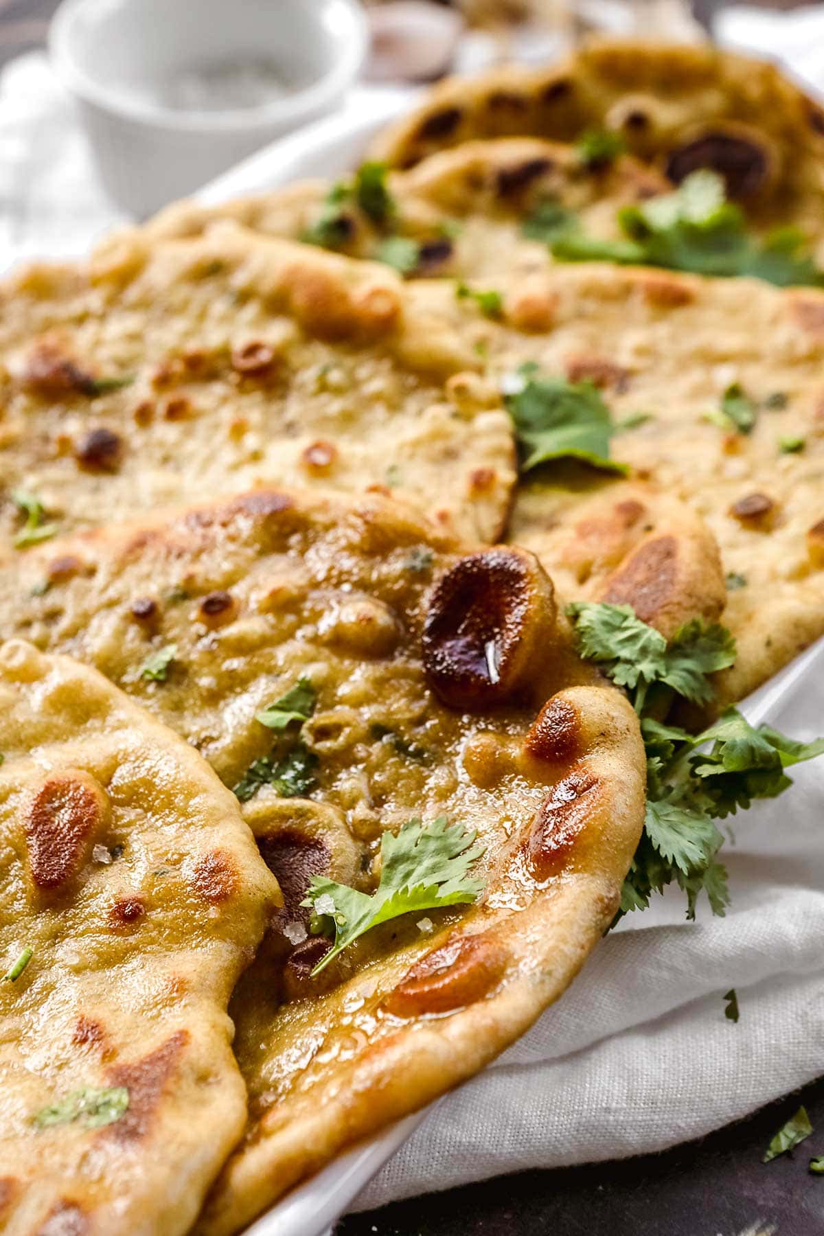 Garlic Naan in serving dish with cilantro garnish