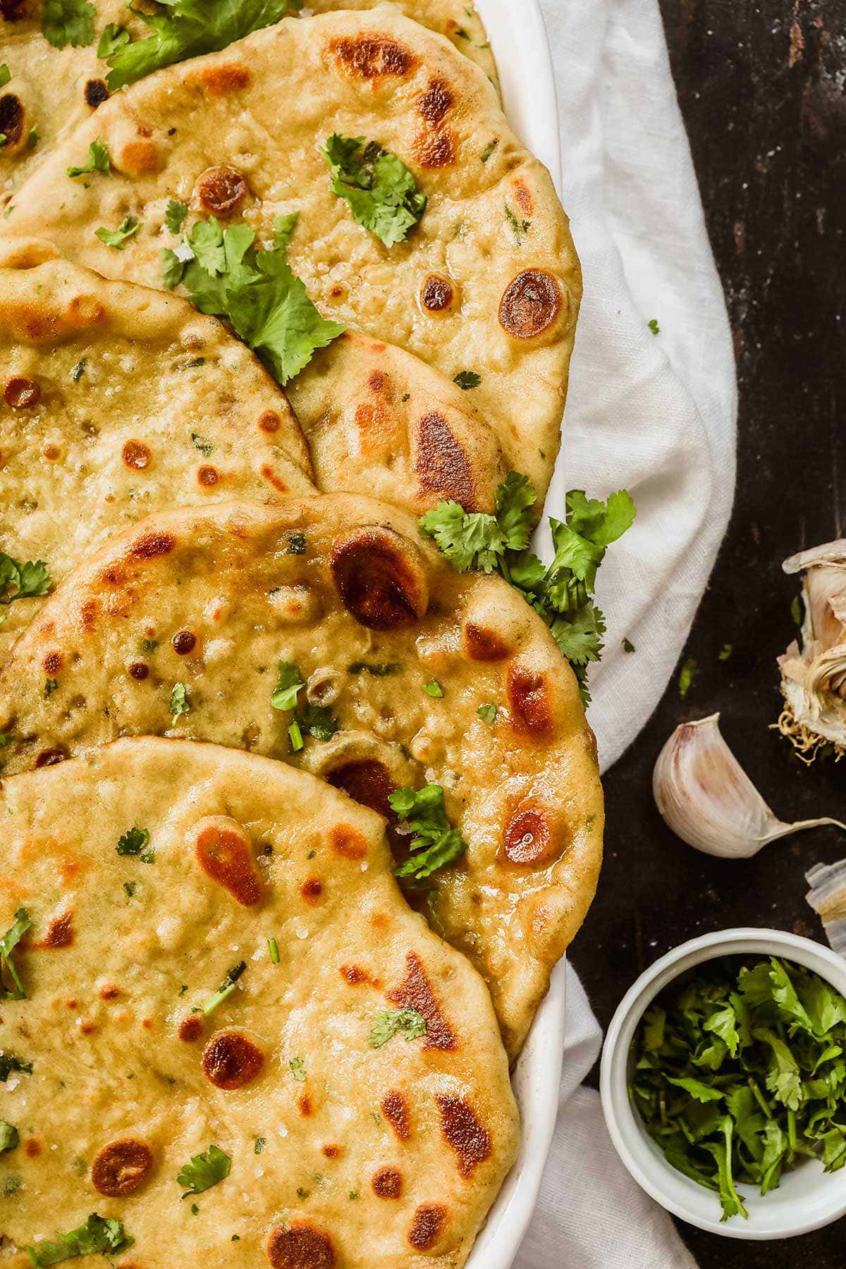 Garlic Naan in serving dish with cilantro garnish