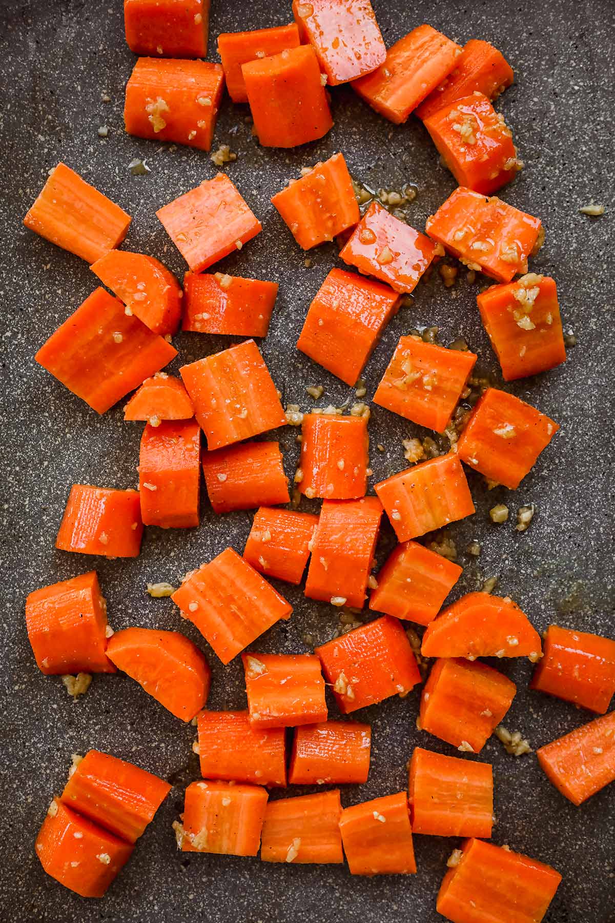 Indian Spiced Honey Roasted Carrots coated with seasonings on baking sheet