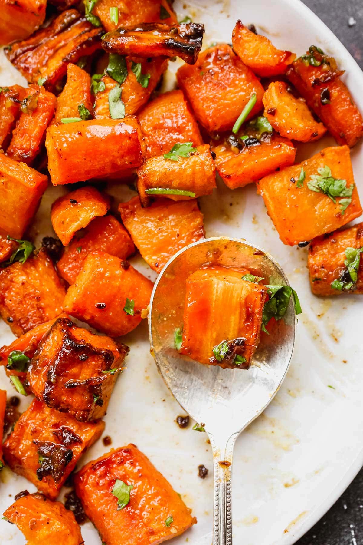 Indian Spiced Honey Roasted Carrots on serving plate with spoon