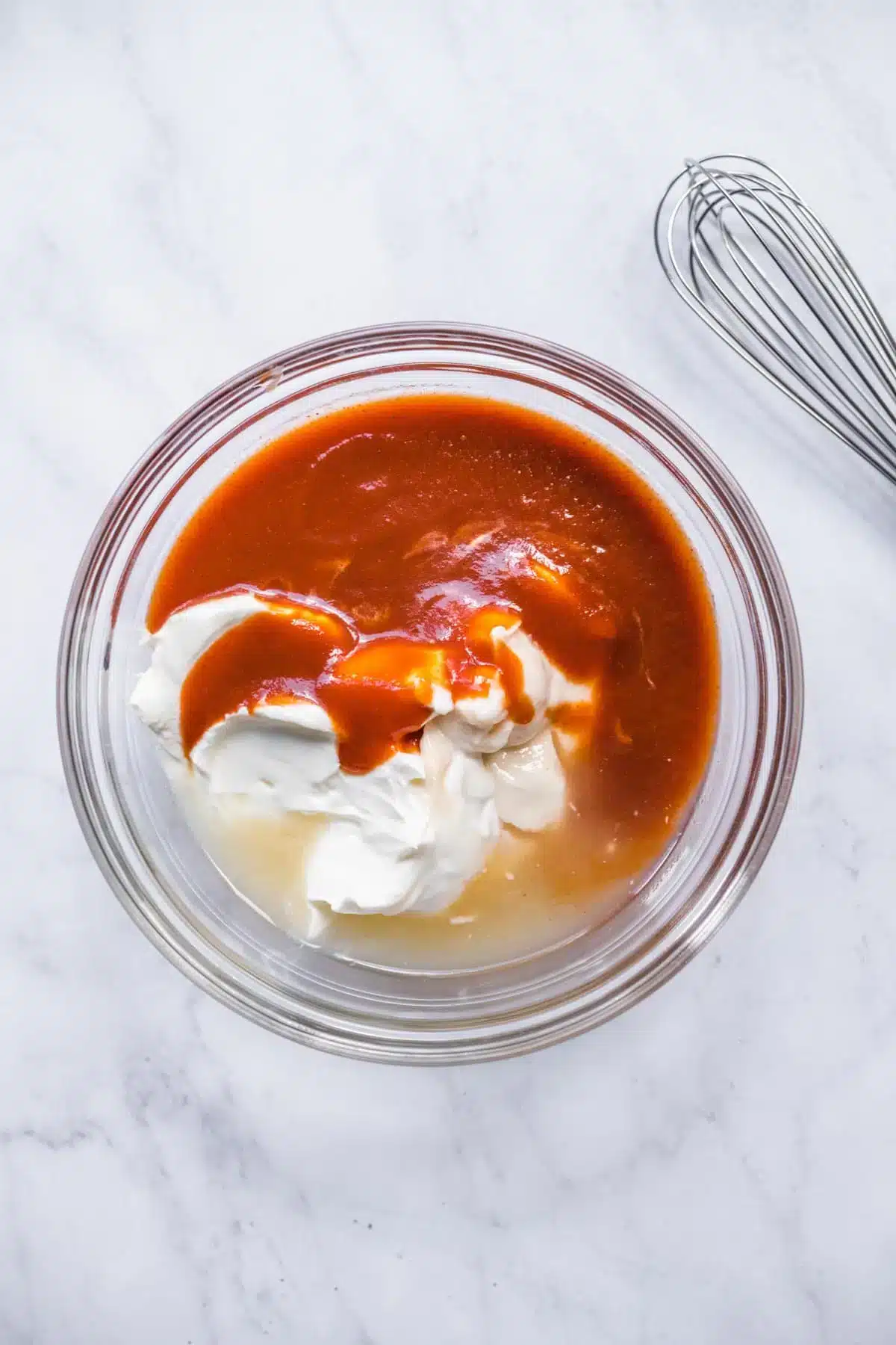 Unmixed dressing ingredients in a glass bowl