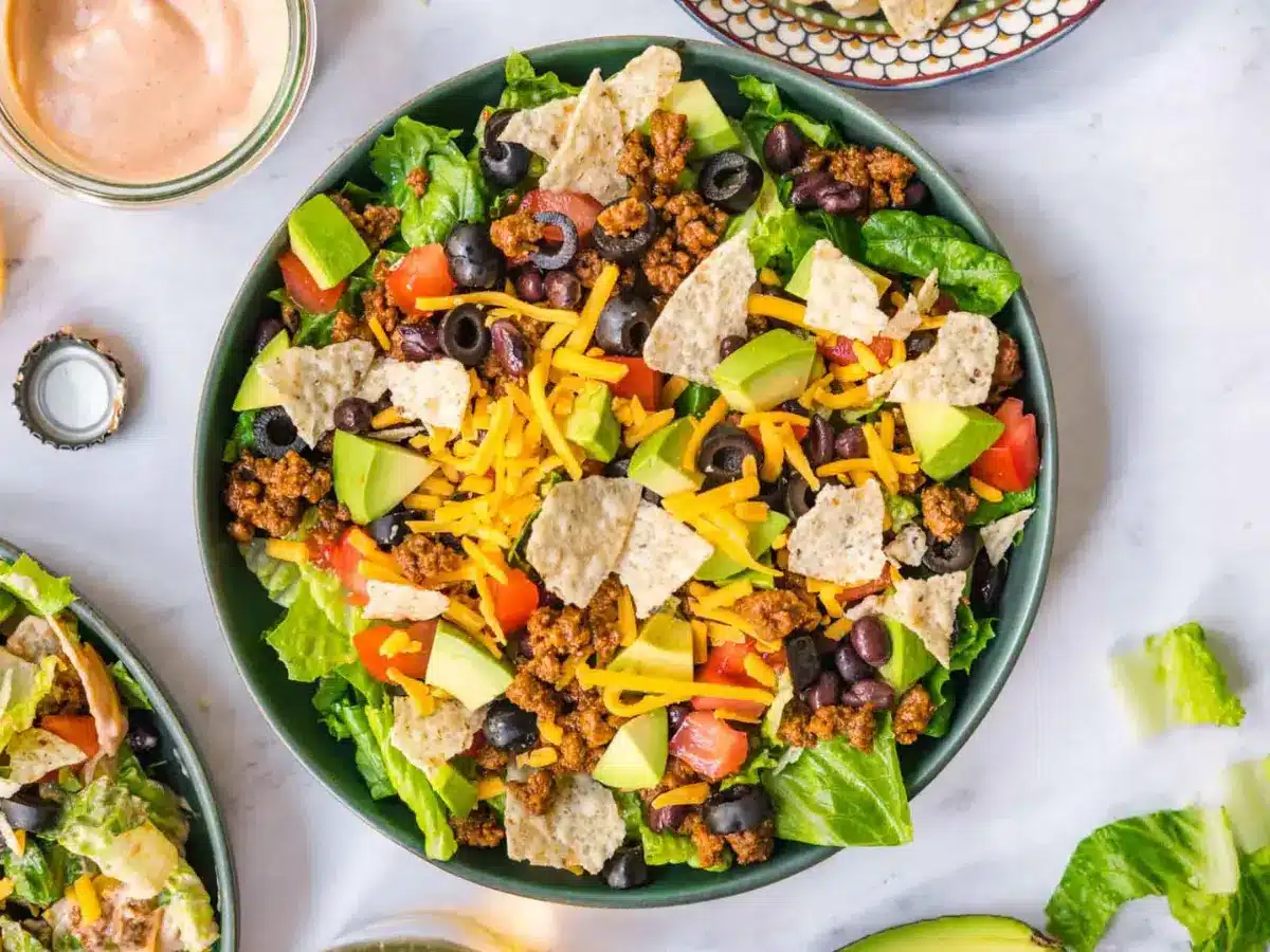 Zoomed out image of salad in a green bowl on grey counter