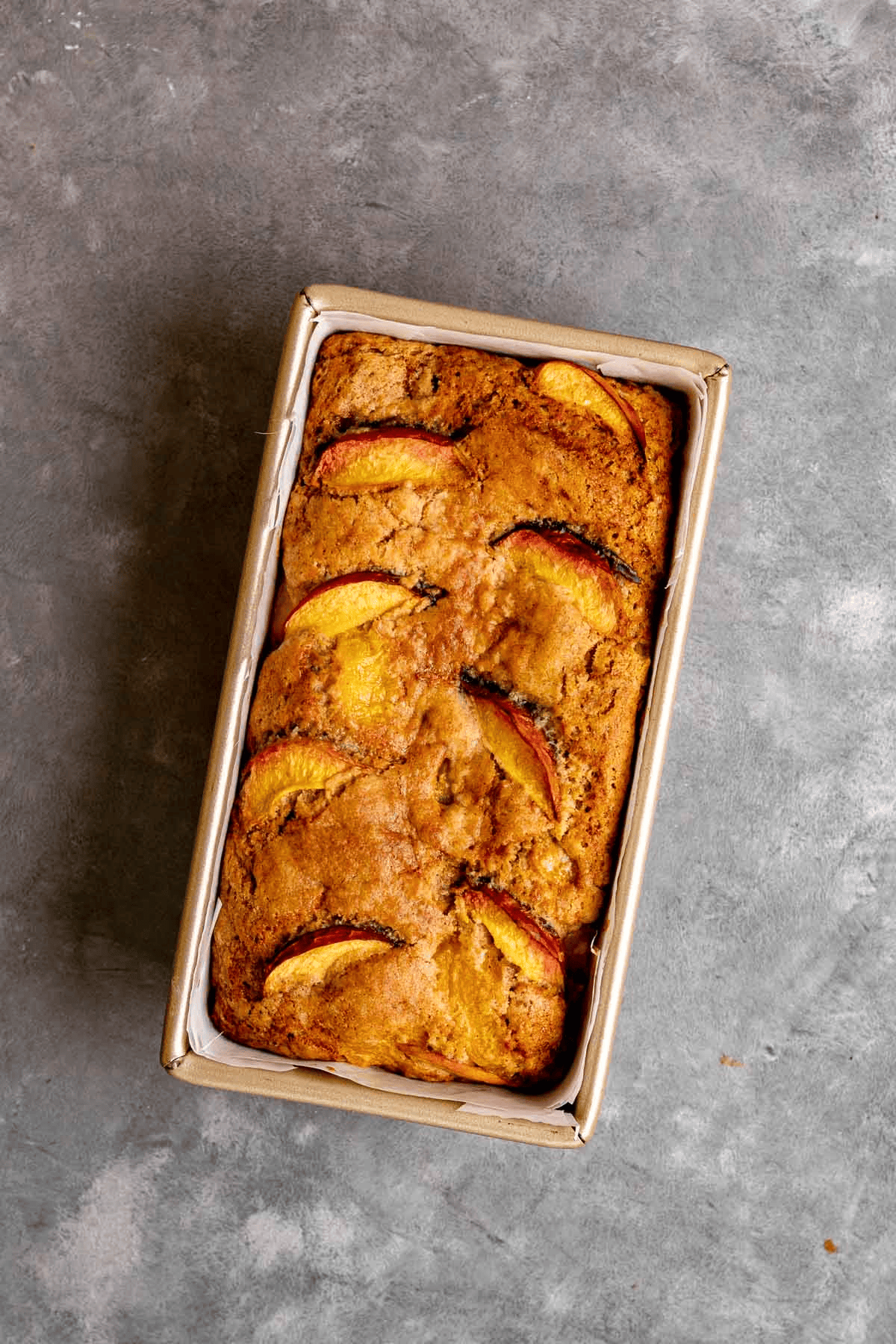 Baked bread loaf with peach slices shown at the top