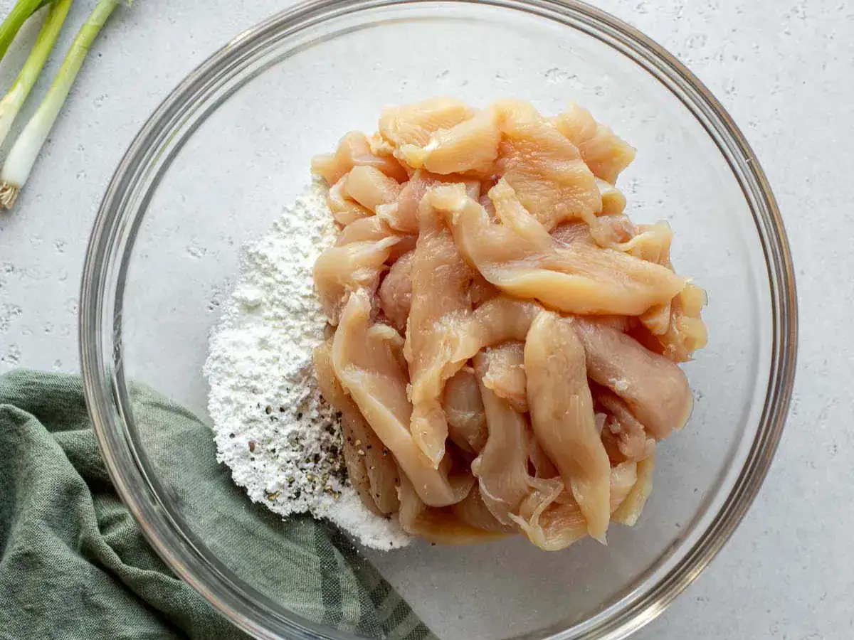 Cornstarch mixture and chicken in bowl.
