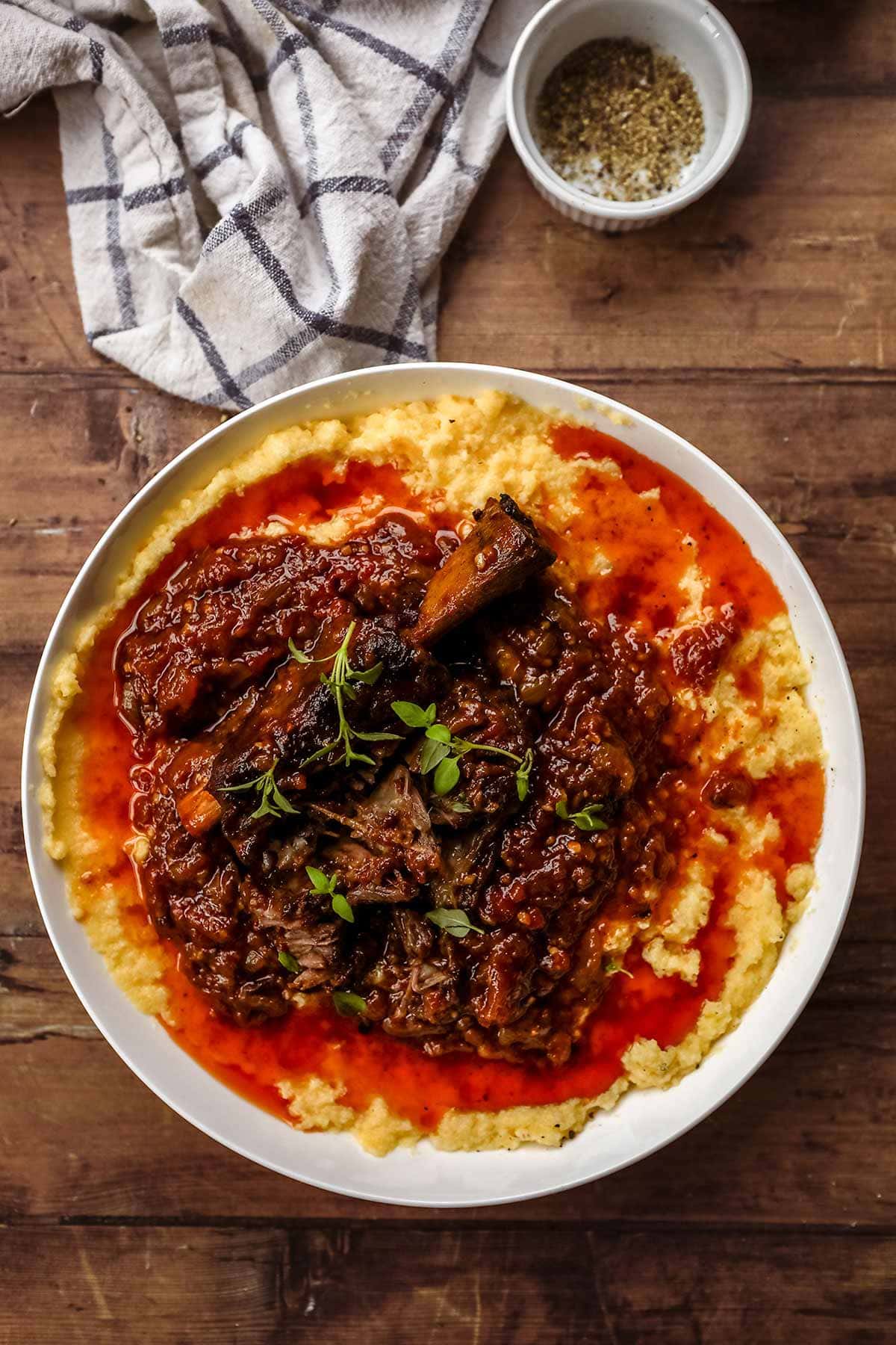 Baked Creamy Polenta in bowl with meat and sauce