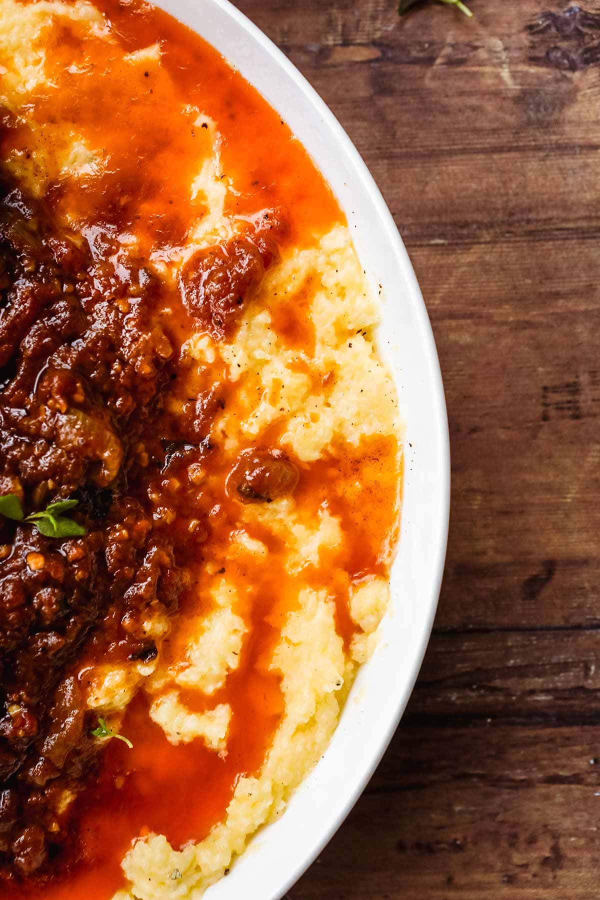 Baked Creamy Polenta in bowl with meat and sauce