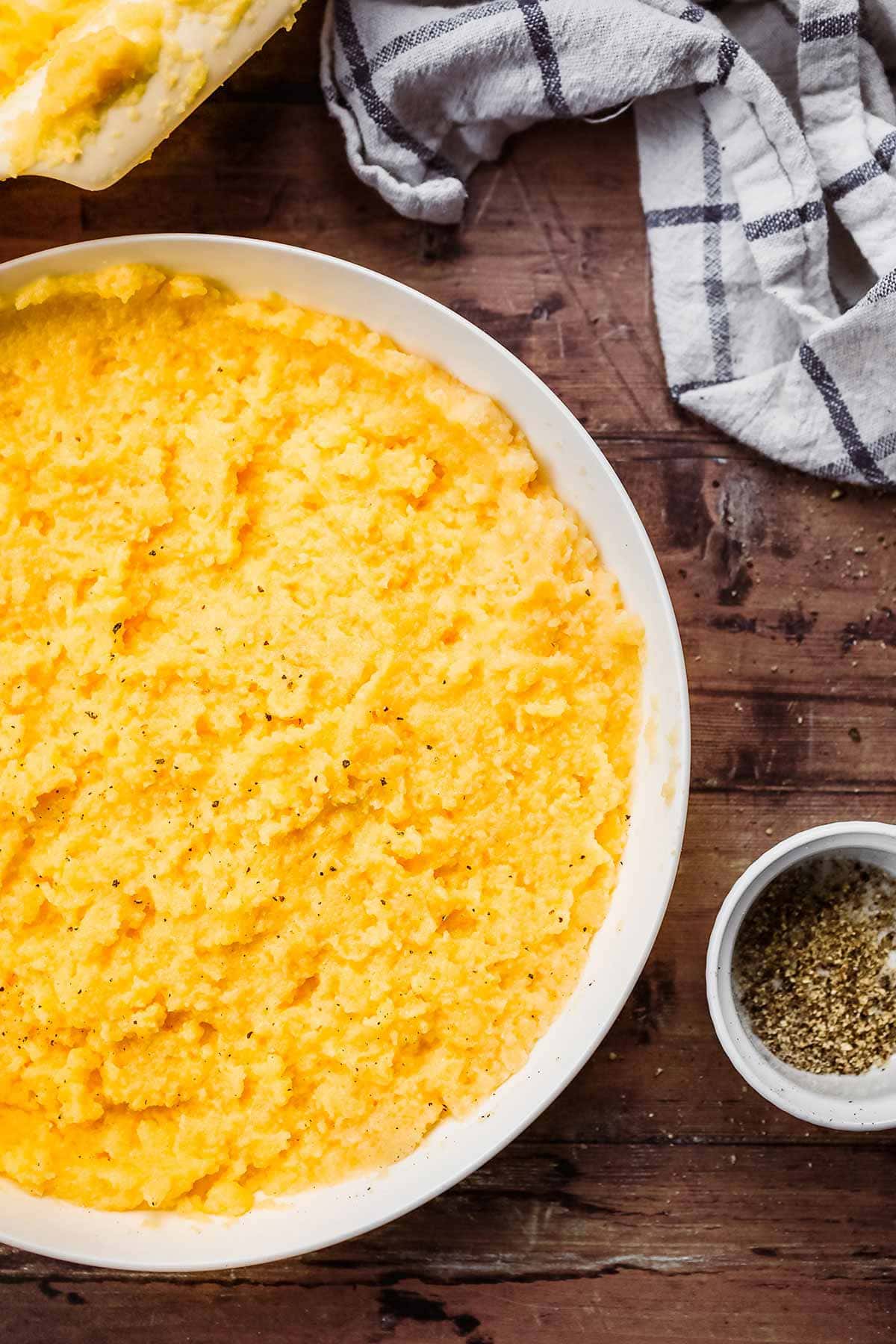 Baked Creamy Polenta in serving bowl with ground black pepepr
