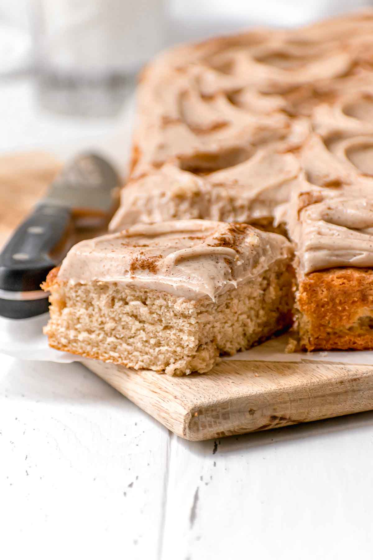 Snickerdoodle Sheet Cake with cinnamon buttercream and cinnamon dusted on top sliced on board