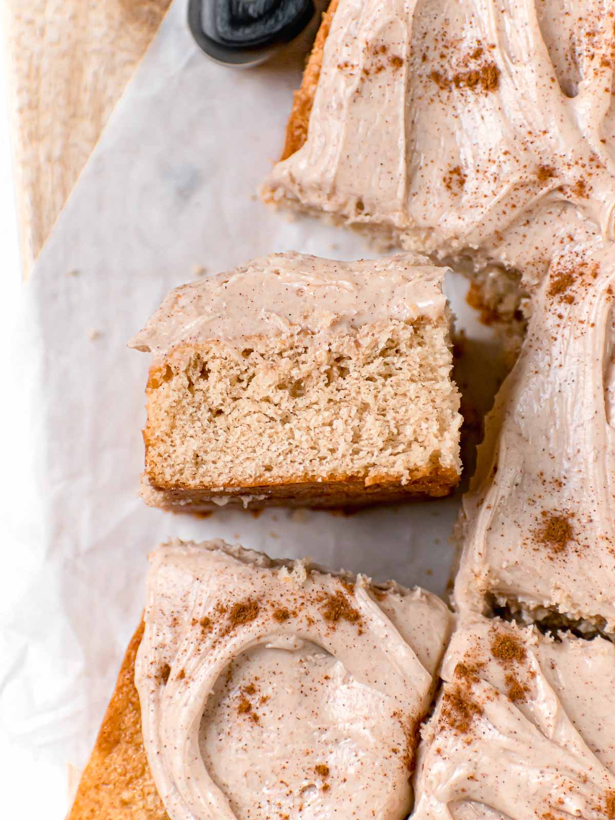 Snickerdoodle Sheet Cake with cinnamon buttercream and cinnamon dusted on top sliced on board