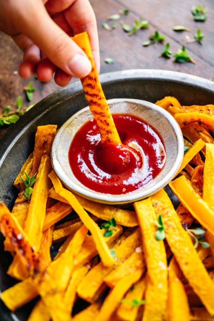 Butternut Squash Fries dipping in ketchup