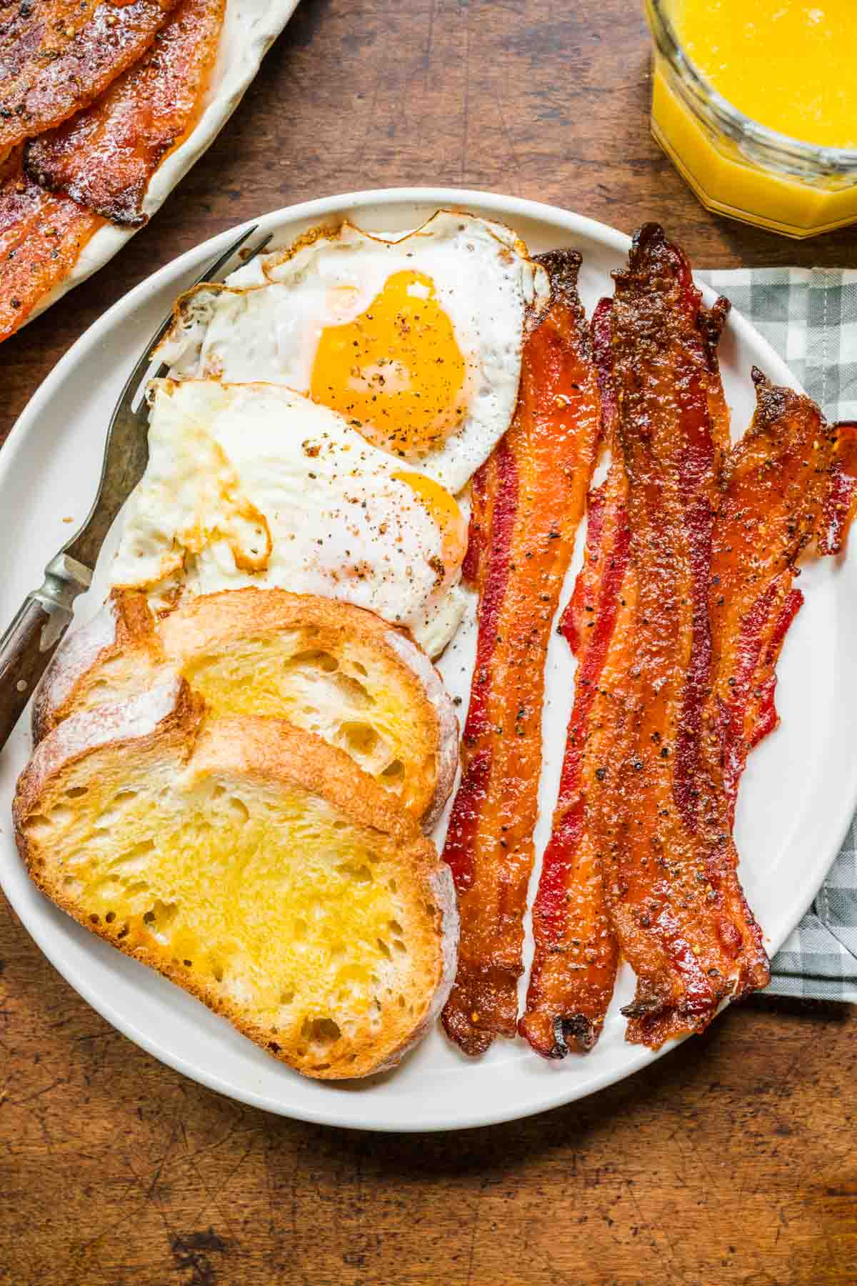 Candied Bacon on plate with eggs and toast