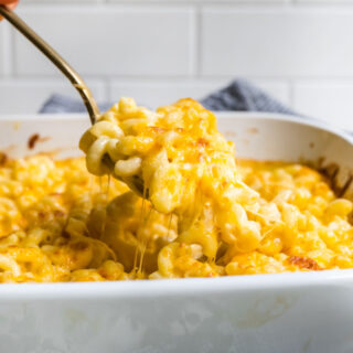 Mac and Cheese being spooned from baking dish 4x3