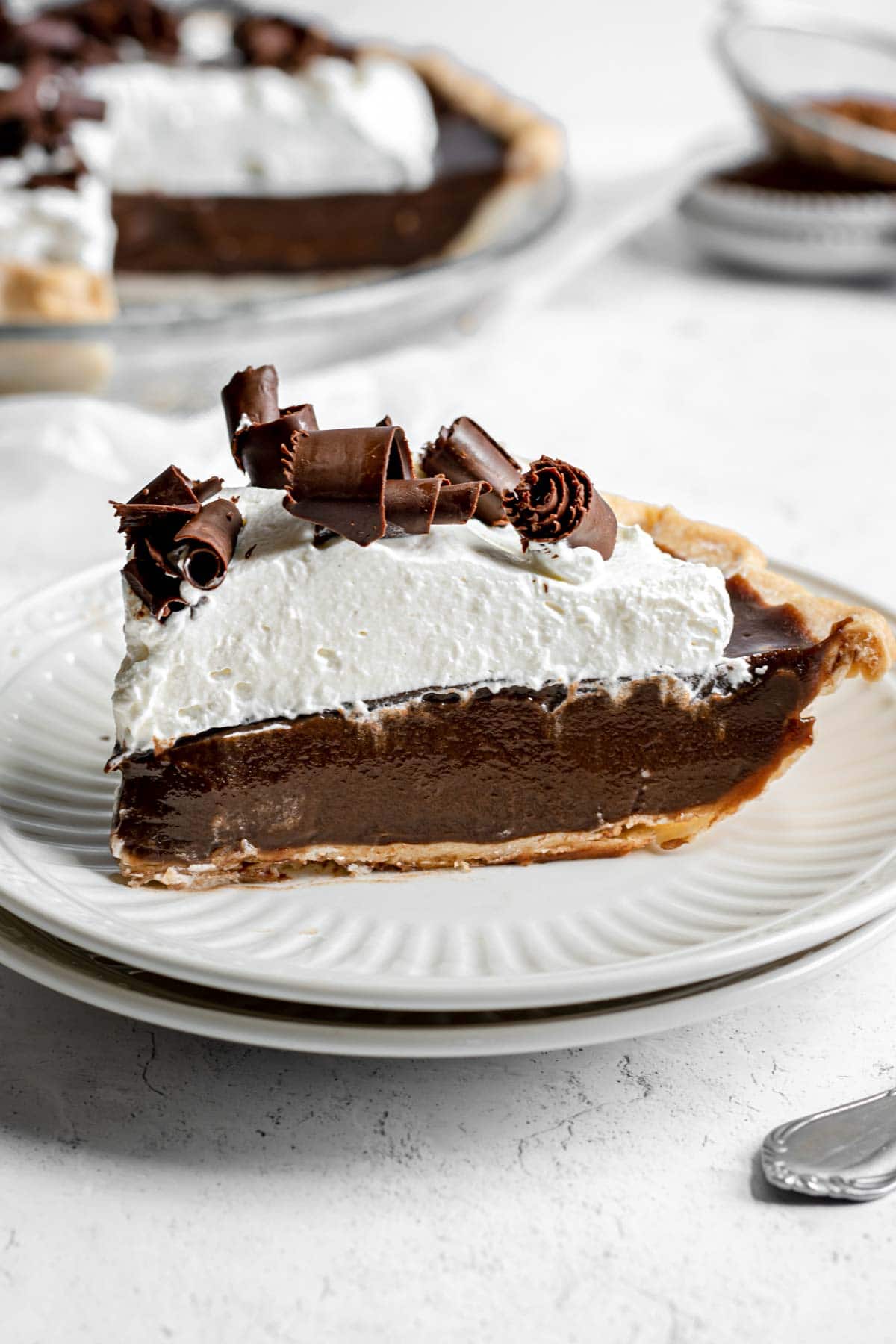 Chocolate Cream Pie with whipped cream and chocolate shavings on serving plate