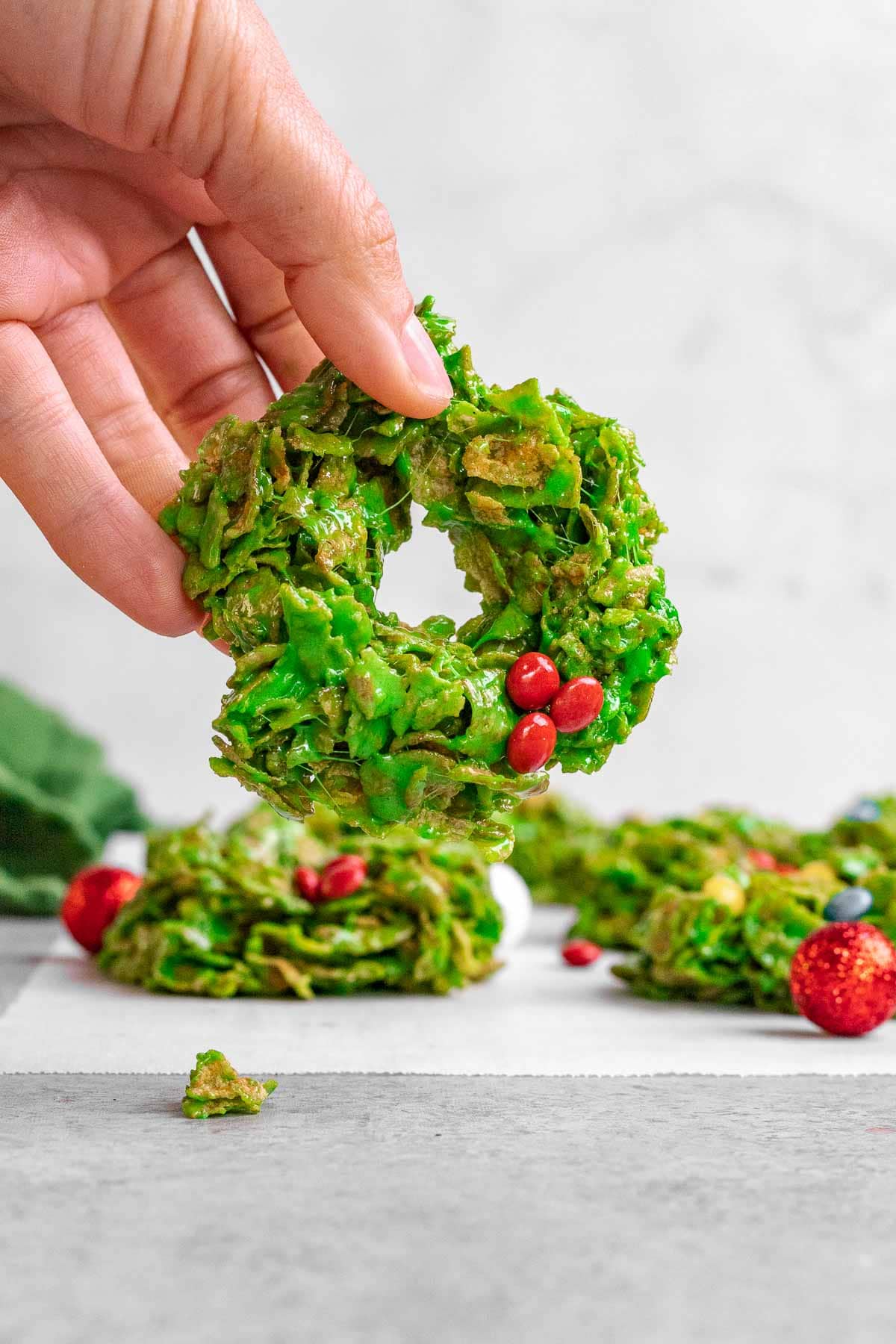 A hand holds up a Christmas Wreath Cookie.