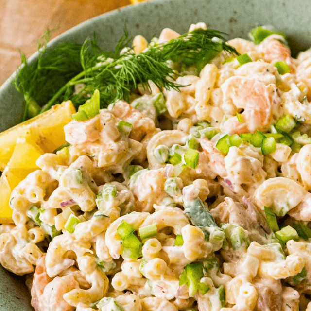 silky seafood noodles with veggies in a bowl with a lemon slice