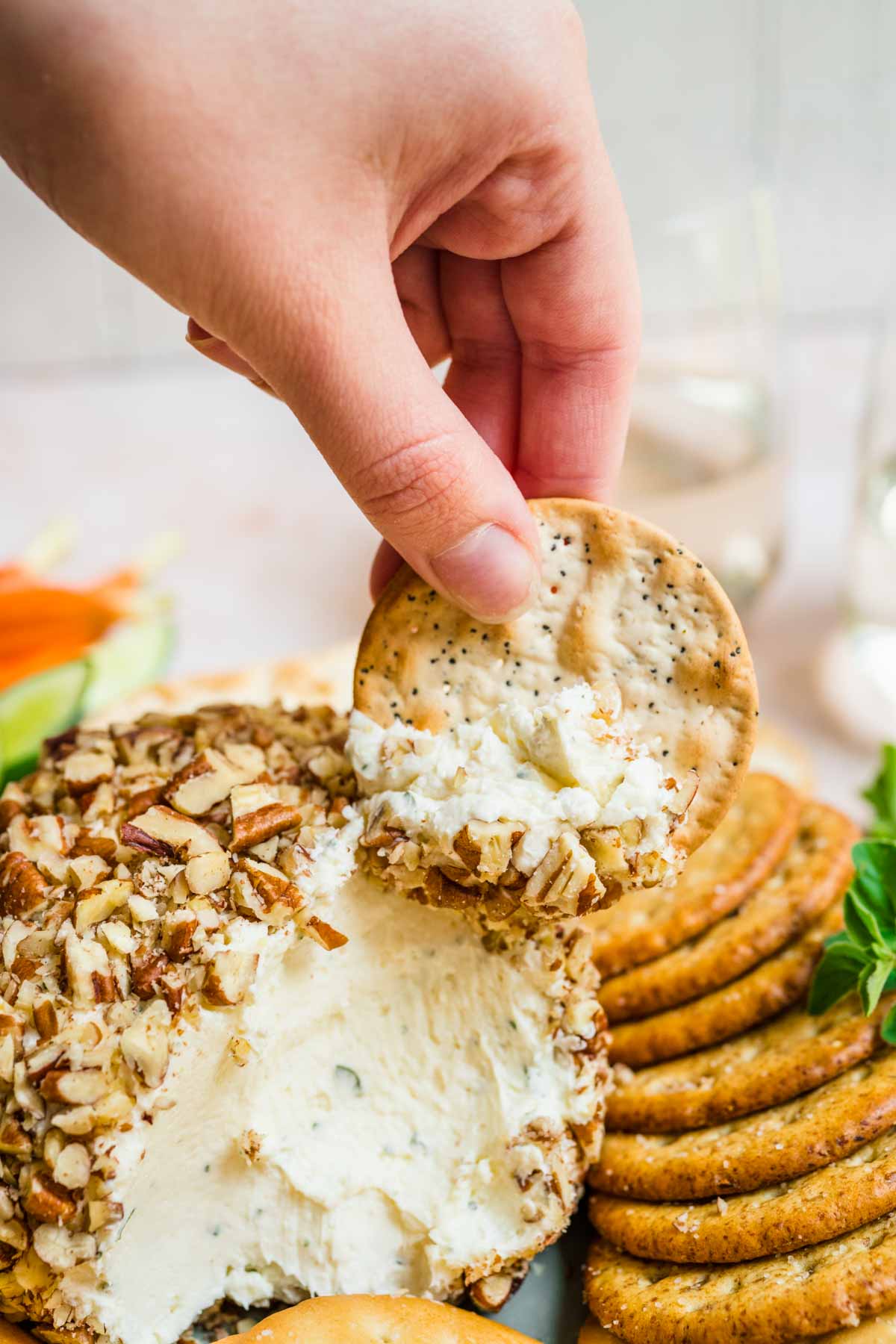 Garlic Parmesan Cheese Ball with scoop taken on serving plate with crackers and veggies