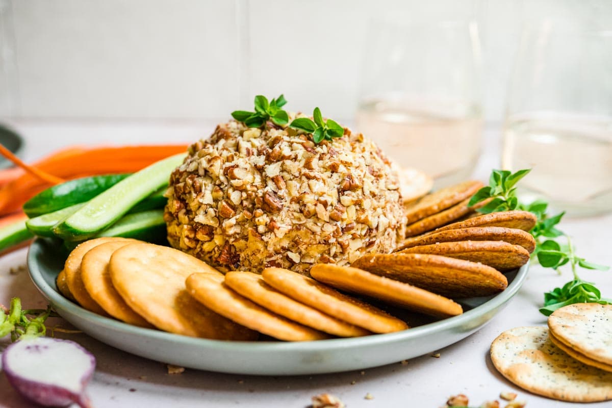 Garlic Parmesan Cheese Ball on serving plate with crackers and veggies