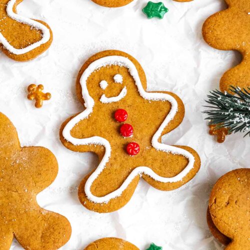 Gingerbread men cookies displayed on white parchment paper.