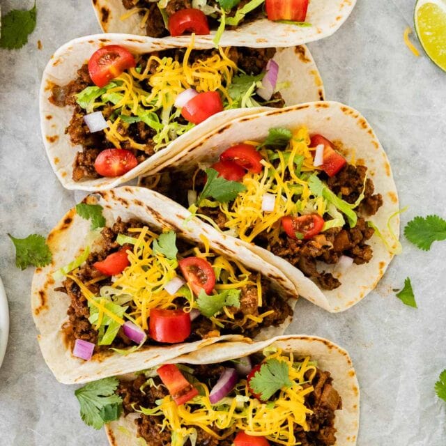 Ground Beef Soft Tacos finished tacos with toppings, lined up, 1x1
