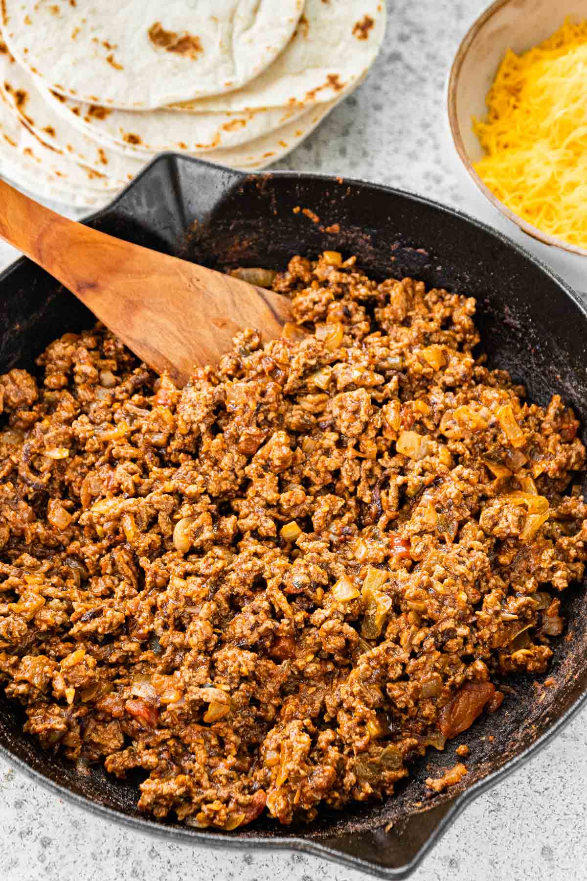 Ground Beef Soft Tacos stirring meat with wooden spoon filling after the seasonings added and cooked down