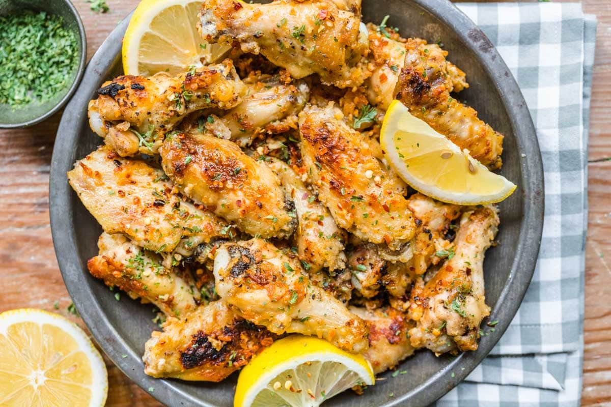 Lemon Parmesan Chicken Wings on serving plate with lemon wedges