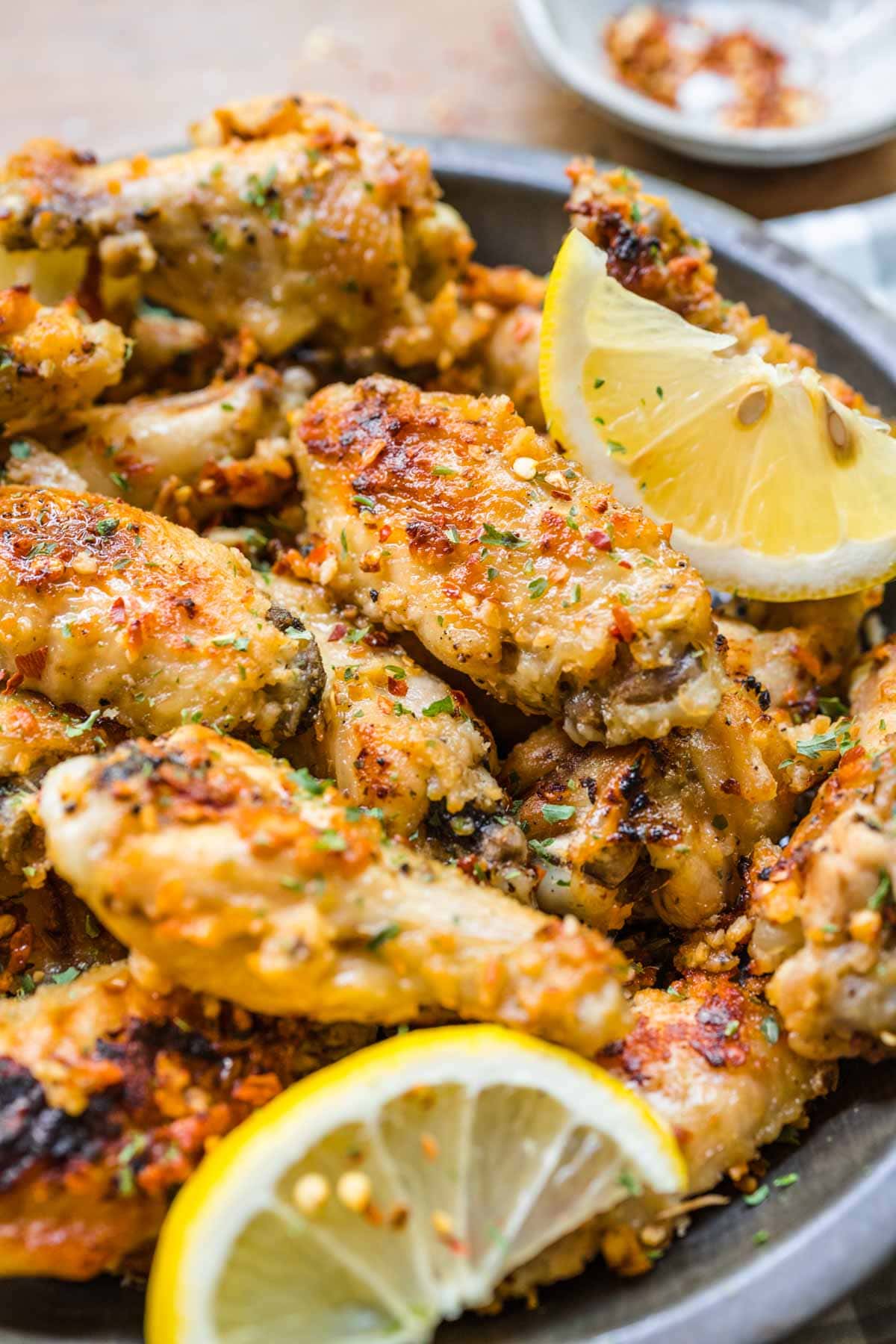 Lemon Parmesan Chicken Wings on serving plate with lemon wedges