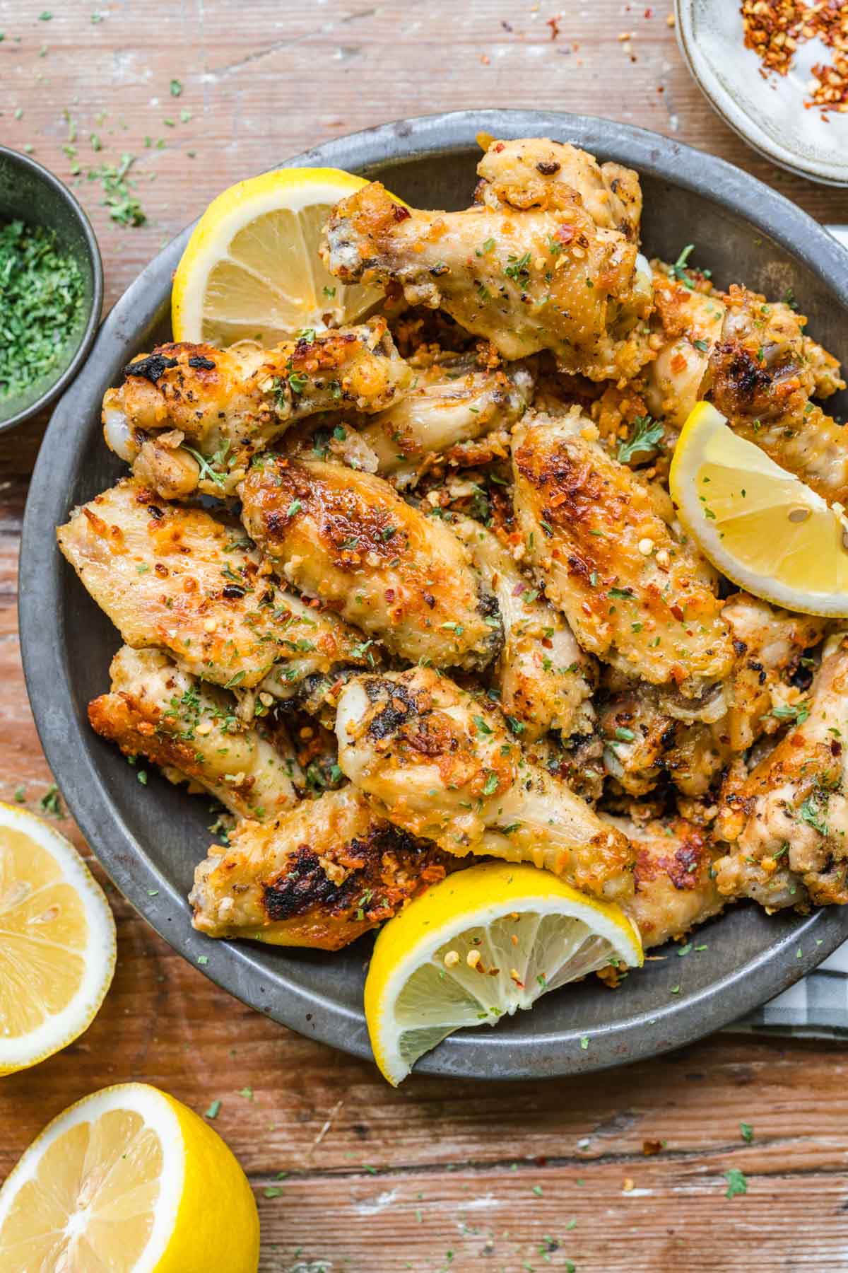 Lemon Parmesan Chicken Wings on serving plate with lemon wedges