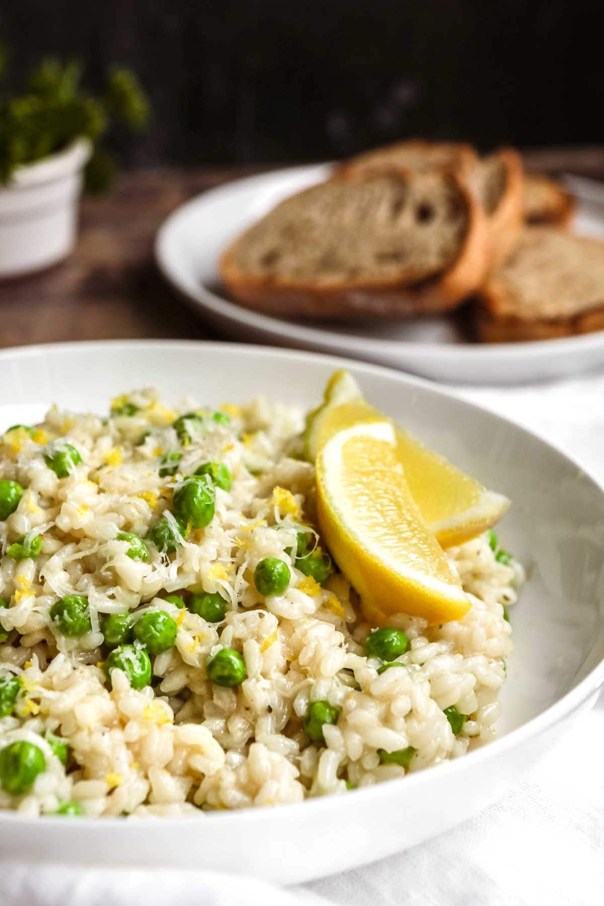 Lemon Parmesan Pea Risotto plated with lemon wedge garnish