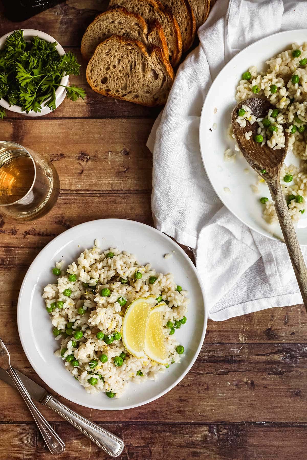 Lemon Parmesan Pea Risotto plated with lemon wedge garnish