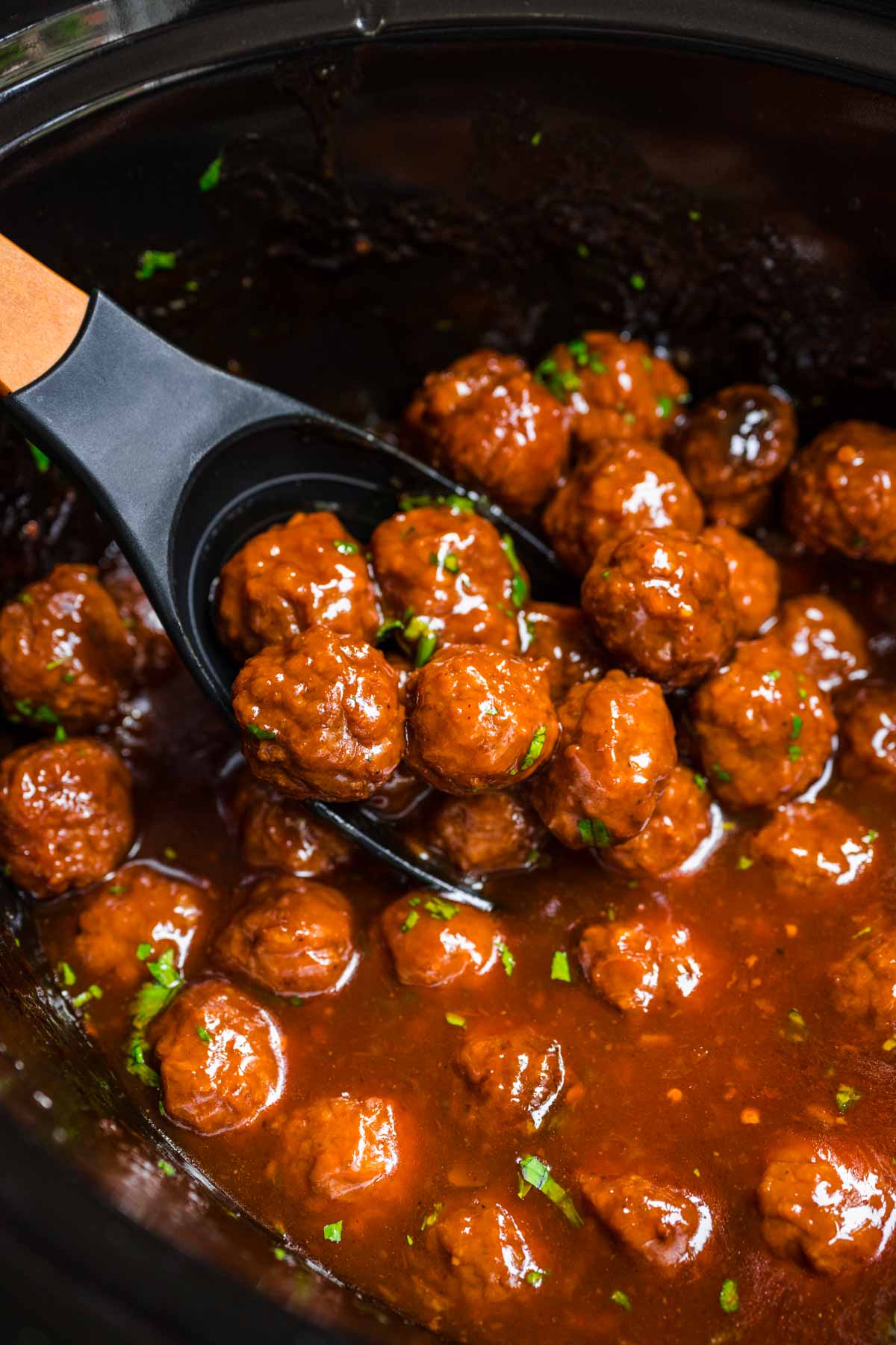 Marmalade Meatballs in sauce in crock pot with spoon