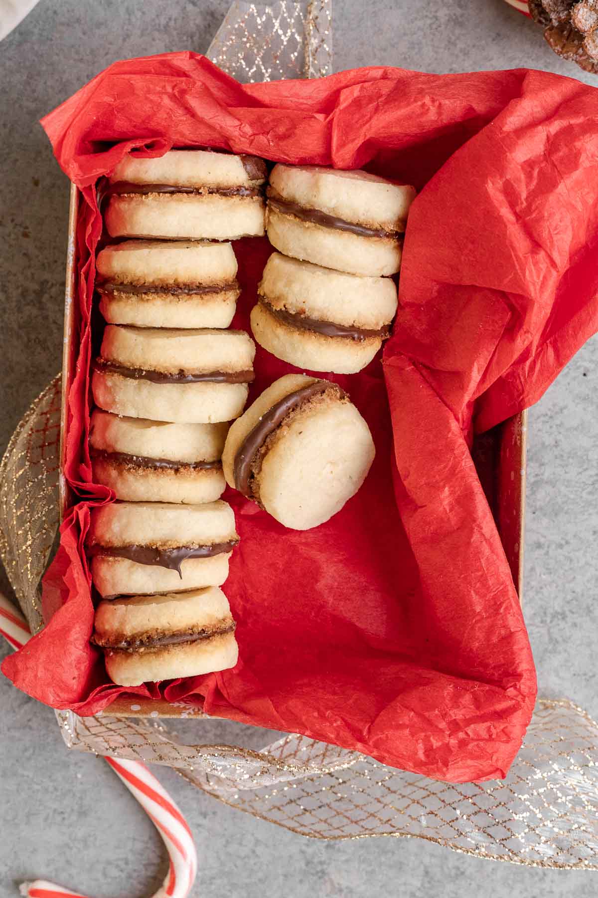 Peppermint Sandwich Cookies baked and filled in box with red tissue paper