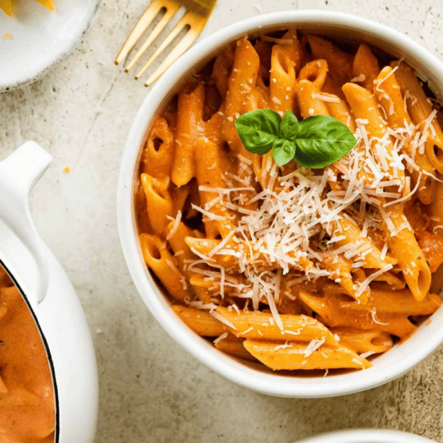 pasta in a bowl with pot of pasta on side